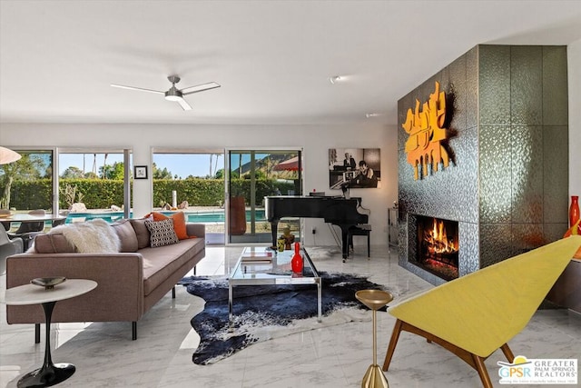 living room with ceiling fan and a fireplace