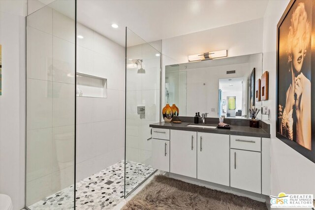 bathroom with vanity and tiled shower