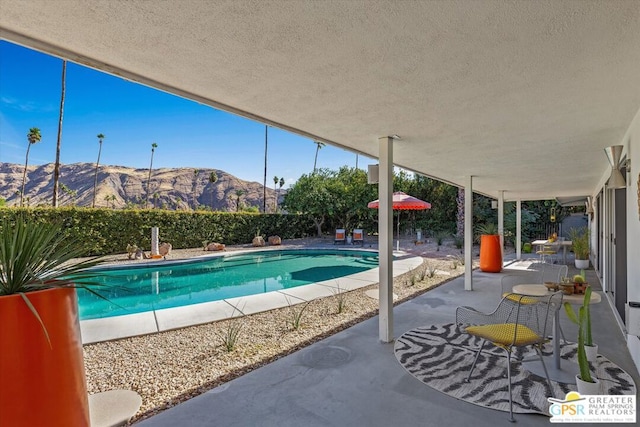 view of pool featuring a mountain view and a patio