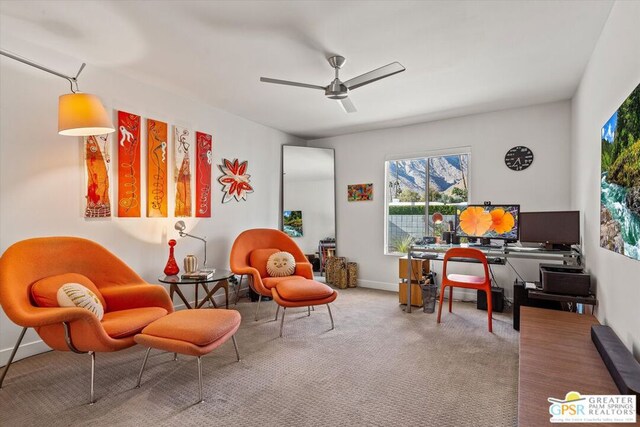 carpeted home office featuring ceiling fan