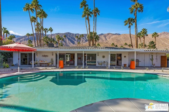 view of pool with a patio area and a mountain view