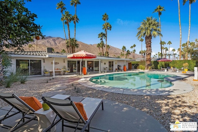 view of swimming pool with a mountain view and a patio