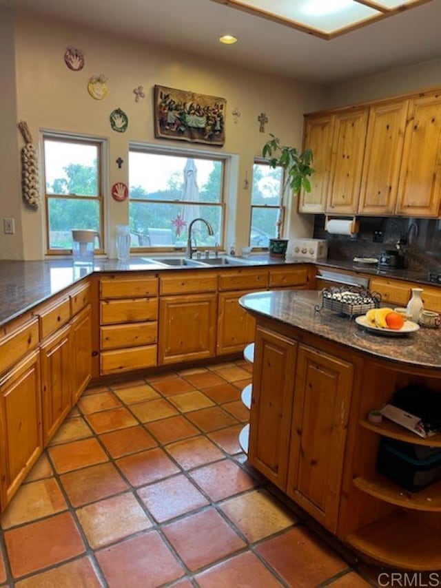 kitchen with light tile patterned floors, backsplash, and sink