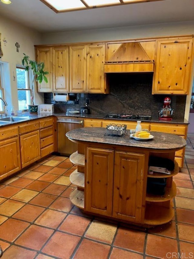 kitchen featuring backsplash, dishwasher, custom exhaust hood, sink, and gas stovetop