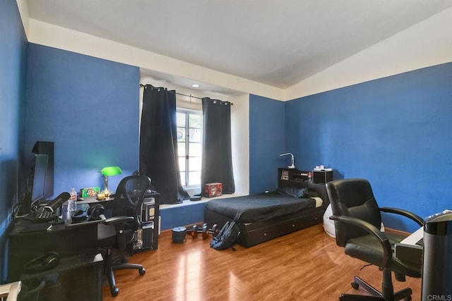 bedroom with lofted ceiling and hardwood / wood-style flooring