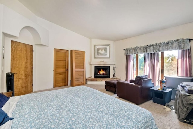 bedroom with lofted ceiling and light colored carpet