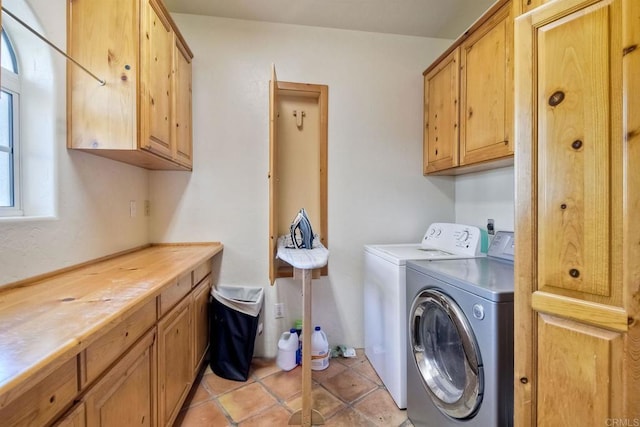 laundry room featuring light tile patterned floors, washer and dryer, and cabinets