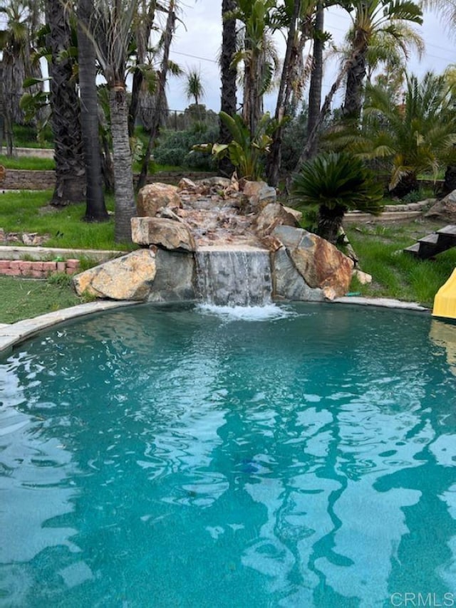 view of swimming pool featuring pool water feature