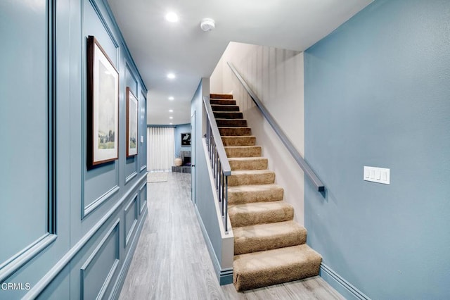 stairway with hardwood / wood-style floors