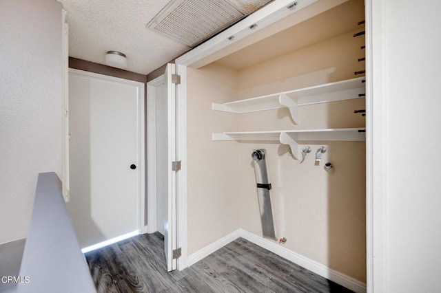 laundry room with washer hookup, a textured ceiling, and hardwood / wood-style flooring