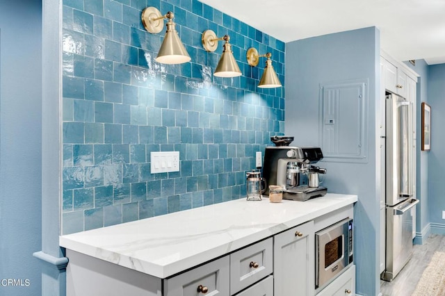 kitchen featuring appliances with stainless steel finishes and light stone counters