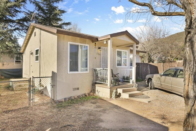 view of front of house with crawl space, fence, and stucco siding