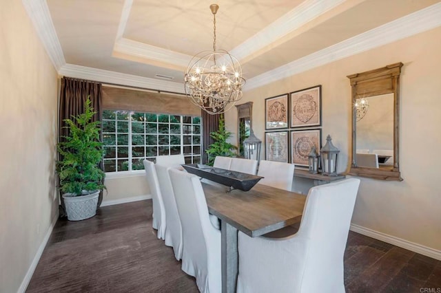 dining area with dark hardwood / wood-style floors, an inviting chandelier, ornamental molding, and a tray ceiling