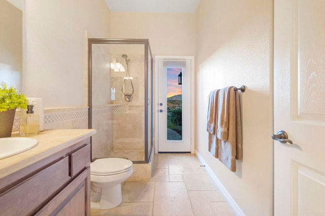 bathroom featuring toilet, vanity, and a shower with door