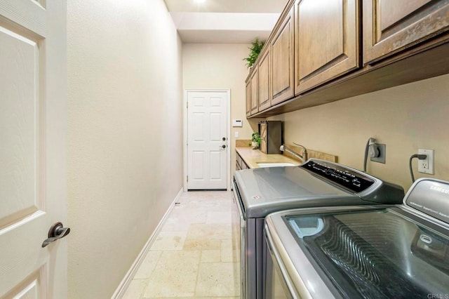 laundry room with sink, independent washer and dryer, and cabinets