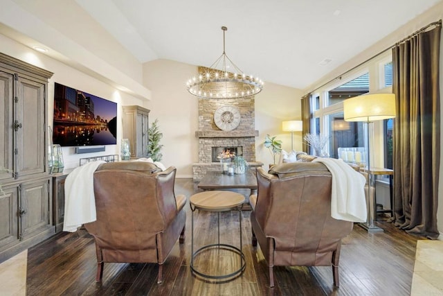 interior space with a chandelier, dark hardwood / wood-style flooring, lofted ceiling, and a stone fireplace