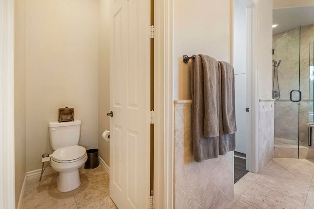 bathroom featuring toilet and a shower with door