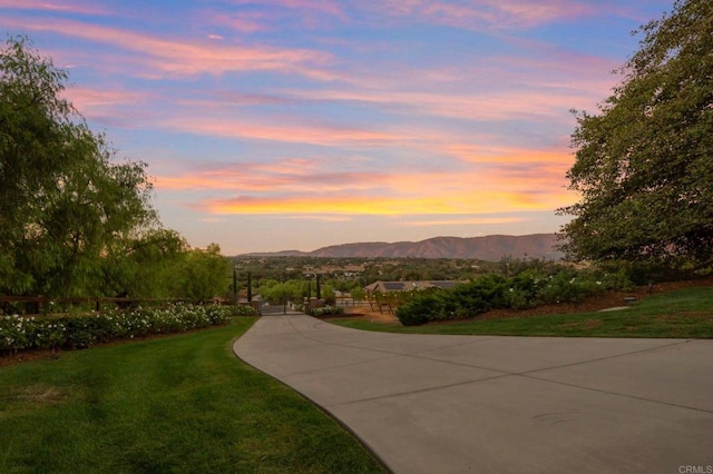 view of property's community with a mountain view and a lawn