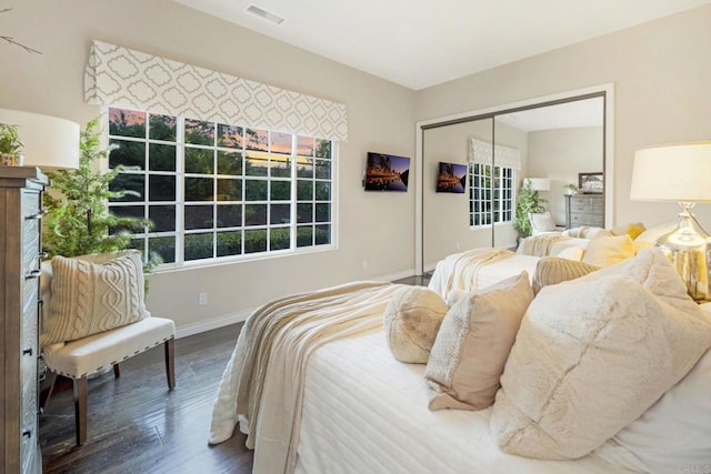 bedroom with dark hardwood / wood-style floors and a closet