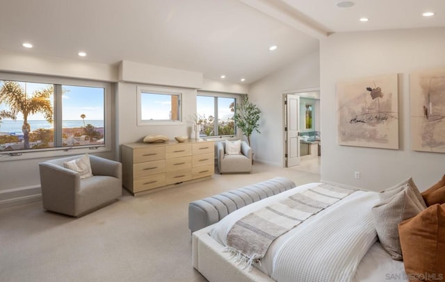 bedroom featuring connected bathroom, light carpet, and vaulted ceiling with beams