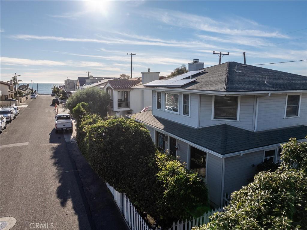 view of property exterior with a water view and solar panels