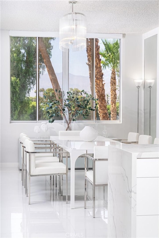 dining space featuring a notable chandelier, a healthy amount of sunlight, and a textured ceiling