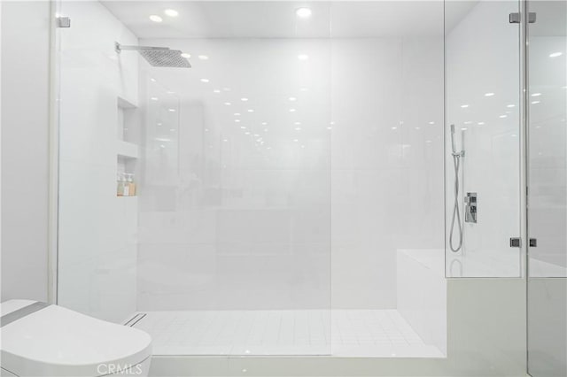 bathroom featuring toilet and tiled shower