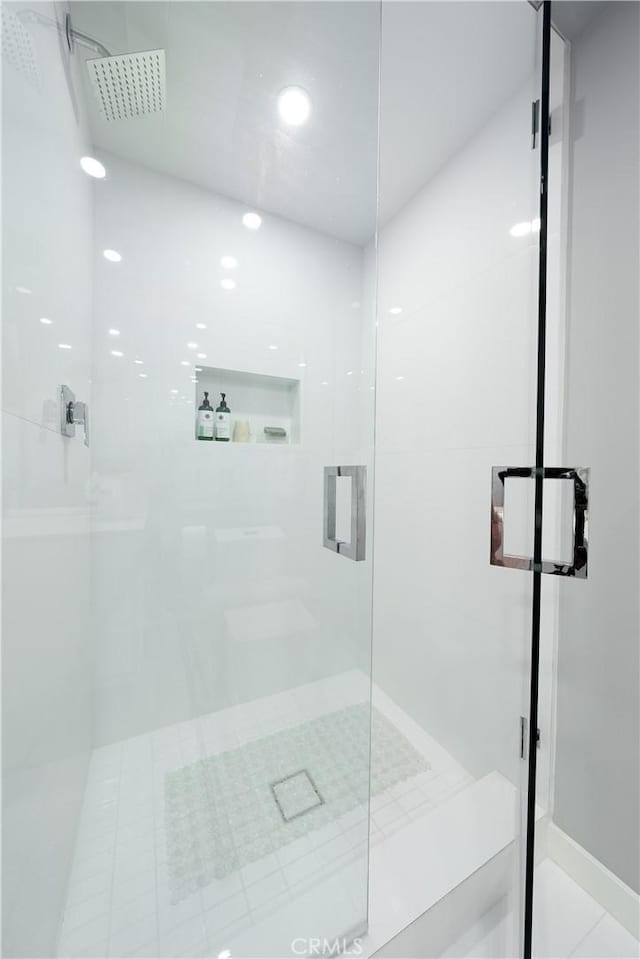 bathroom featuring tile patterned floors and a shower with shower door