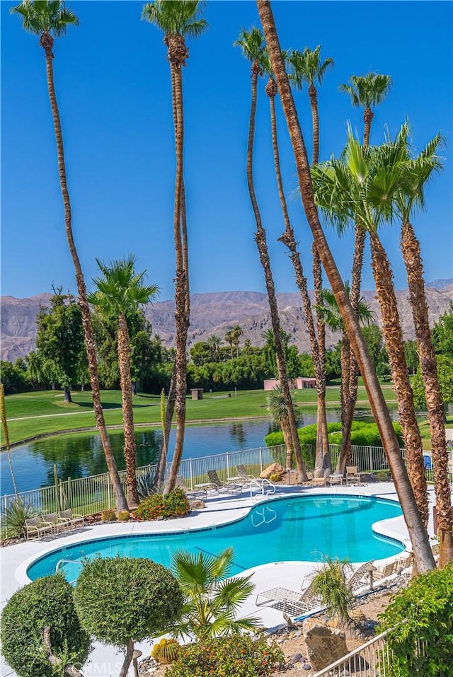 view of swimming pool featuring a patio and a water and mountain view