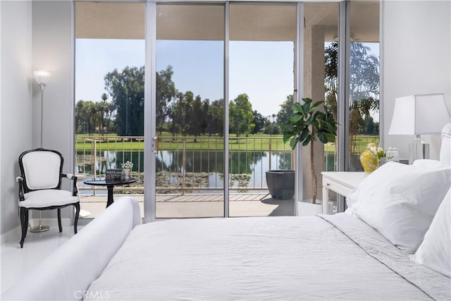 bedroom featuring access to outside, multiple windows, and a water view