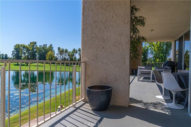 view of patio / terrace with a water view and a balcony