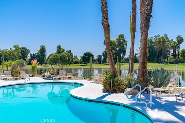 view of pool featuring a water view and a patio