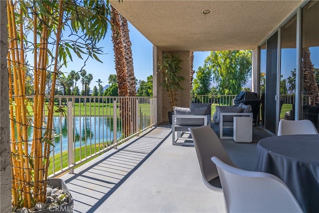 view of patio / terrace featuring a water view and a balcony