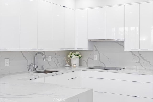 kitchen featuring white cabinets, decorative backsplash, black electric stovetop, and sink