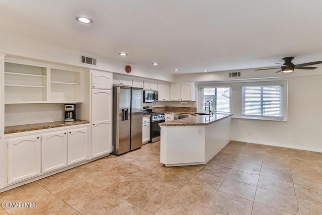 kitchen featuring white cabinets, stainless steel appliances, dark stone countertops, kitchen peninsula, and ceiling fan