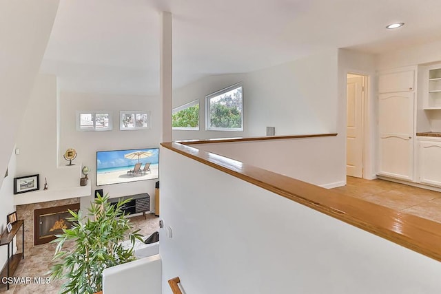 stairs featuring lofted ceiling and a premium fireplace