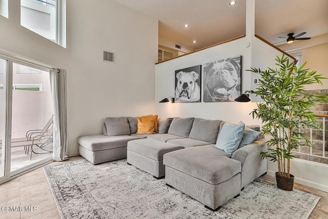 living room featuring ceiling fan and a towering ceiling