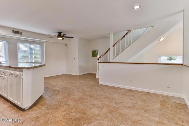 kitchen featuring ceiling fan and white cabinets