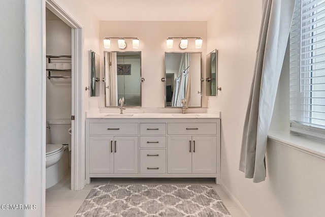 bathroom featuring toilet, vanity, and tile patterned floors