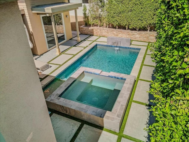 view of swimming pool featuring pool water feature, a patio, and an in ground hot tub