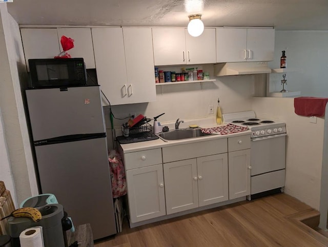 kitchen with stainless steel fridge, sink, white cabinetry, and white range