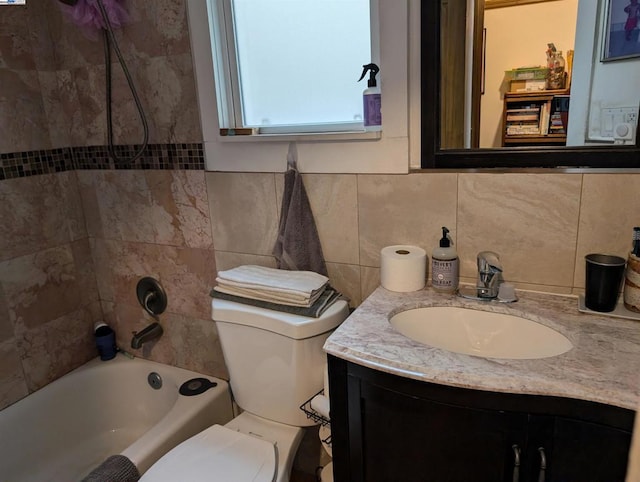 full bathroom with toilet, tiled shower / bath, decorative backsplash, and vanity