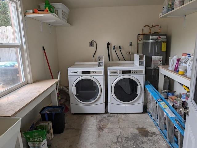 washroom featuring a wealth of natural light, washer and dryer, and secured water heater