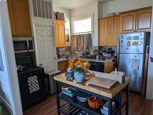 kitchen with black appliances, dark wood-type flooring, sink, and tasteful backsplash