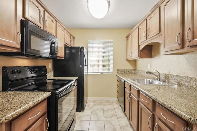 kitchen featuring light stone counters, sink, light tile patterned floors, and black appliances