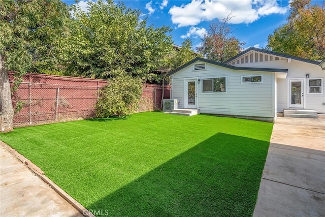 rear view of property featuring ac unit, a yard, and a patio