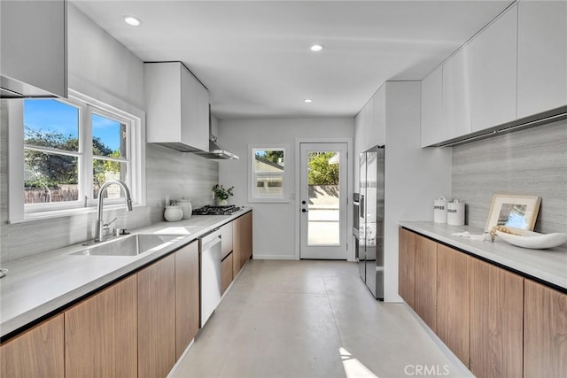 kitchen with tasteful backsplash, sink, white cabinetry, and stainless steel appliances