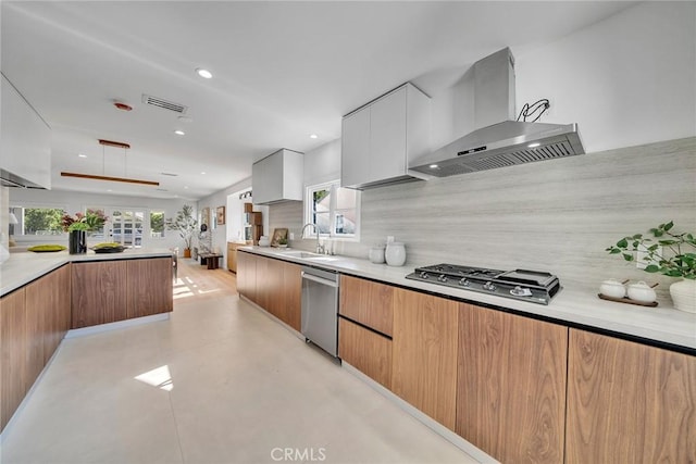 kitchen with tasteful backsplash, extractor fan, sink, white cabinetry, and stainless steel appliances