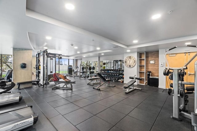 workout area with a tray ceiling