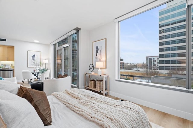 bedroom featuring floor to ceiling windows and light hardwood / wood-style flooring